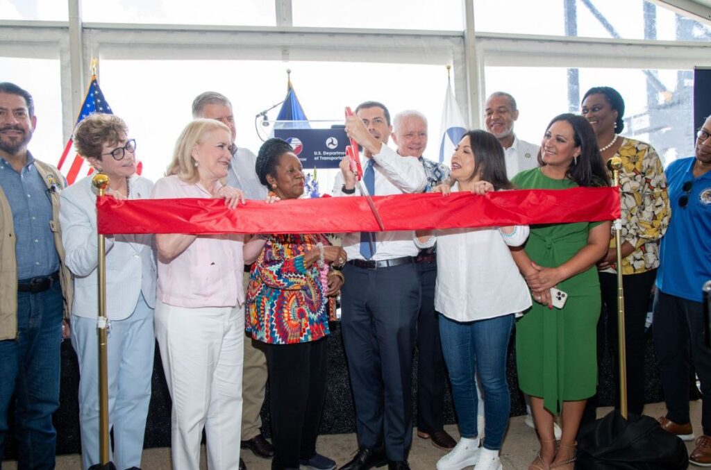Transportation Secretary Pete Buttigieg (center) cuts a ceremonial ribbon marking the completion of Port Houston's Wharf 6 of its Bayport Container Terminal Expansion Project. From left: Harris County Commissioner Adrian Garcia, MARAD Administrator Ann Philips, Congresswoman Sylvia Garcia, Port Houston Exec. Dir. Roger Guenther, Congresswoman Sheila Jackson Lee, Port Commissioner Dean Corgey, State Rep. Mary Ann Perez, State Rep Jarvis Johnson, State Rep. Christine Morales, Houston Mayor Vice Pro-Tem Martha Castex-Tatum, Chairman of the Pilot Board for Harris County Ports Captain Reginald McKamie (in blue shirt), and Seabrook Mayor Thom Kolupski